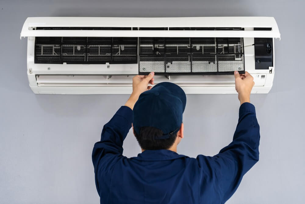 Engineer cleaning and fixing air conditioning unit