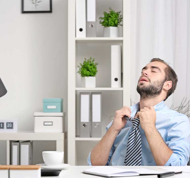 Young man feeling hot in office