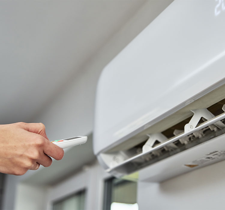 Hand adjusting temperature on air conditioner with remote control, Working air conditioner for comfort temperature in home at hot summer